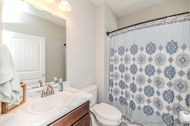 a bathroom with a sink a toilet and shower curtain