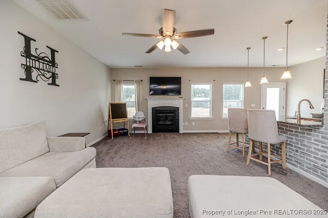 a living room with furniture a fireplace and a flat screen tv