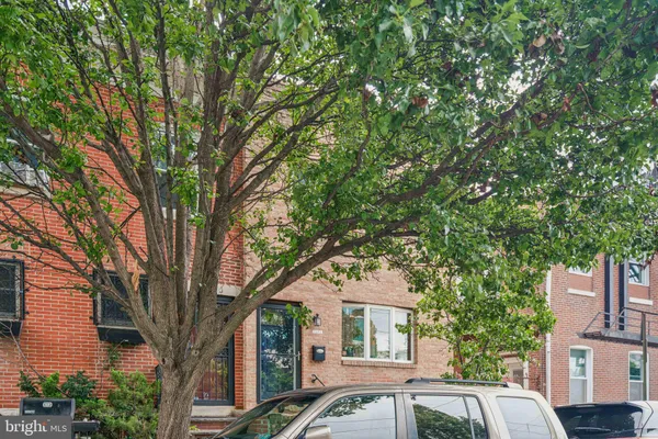 a front view of a house with a tree