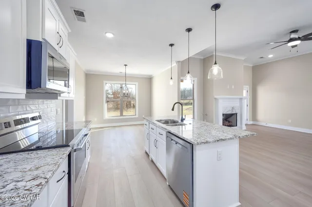 a kitchen with stainless steel appliances granite countertop a sink stove and wooden floor