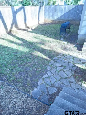 a view of backyard with table and chairs and wooden fence