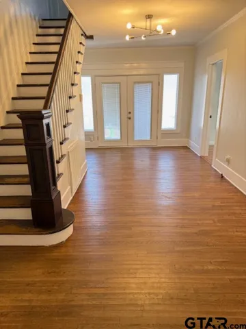 a view of entryway and hall with wooden floor