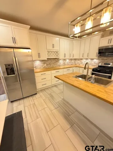 a kitchen with stainless steel appliances a refrigerator sink and cabinets