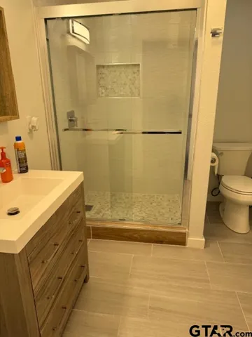 a bathroom with a sink a toilet and shower