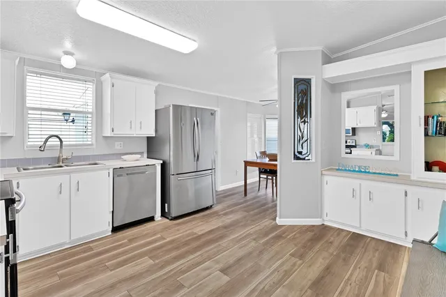 a kitchen with a refrigerator stove and white cabinets
