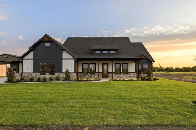 a front view of house with yard patio and lake view