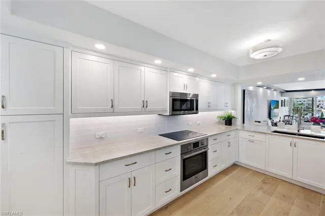 a kitchen with granite countertop white cabinets and white appliances