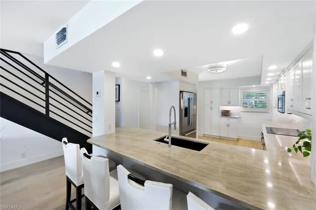 a modern kitchen with stainless steel appliances kitchen island a sink a stove and a window