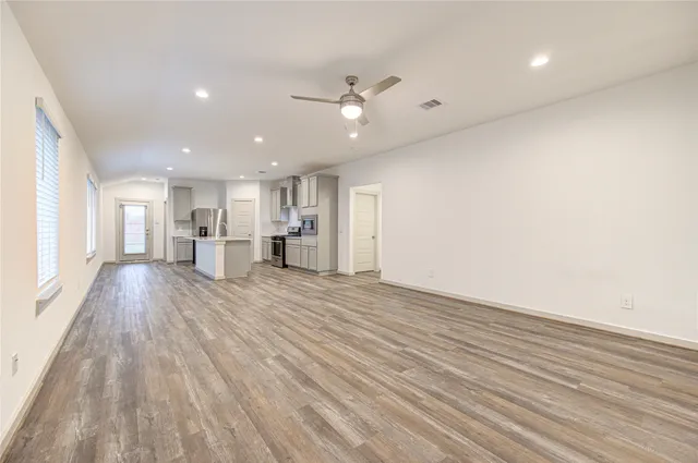 a view of empty room with wooden floor