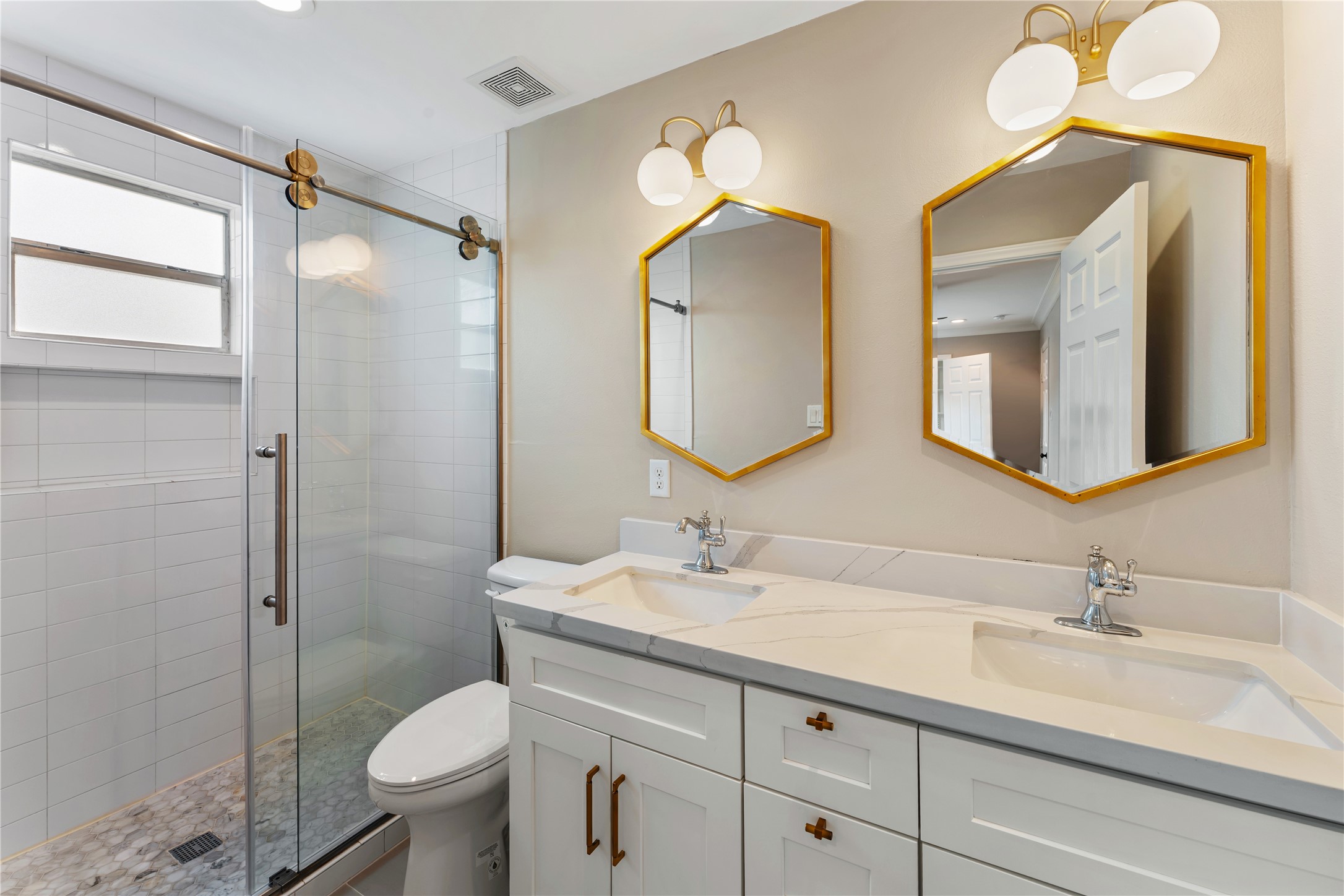 809 East 40th Street Houston, TX 77022 - Photo 16 of 27 Beautifully updated bathroom with dual sinks, modern fixtures, and stylish finishes. The walk-in shower with glass enclosure adds a sleek, spa-like touch.