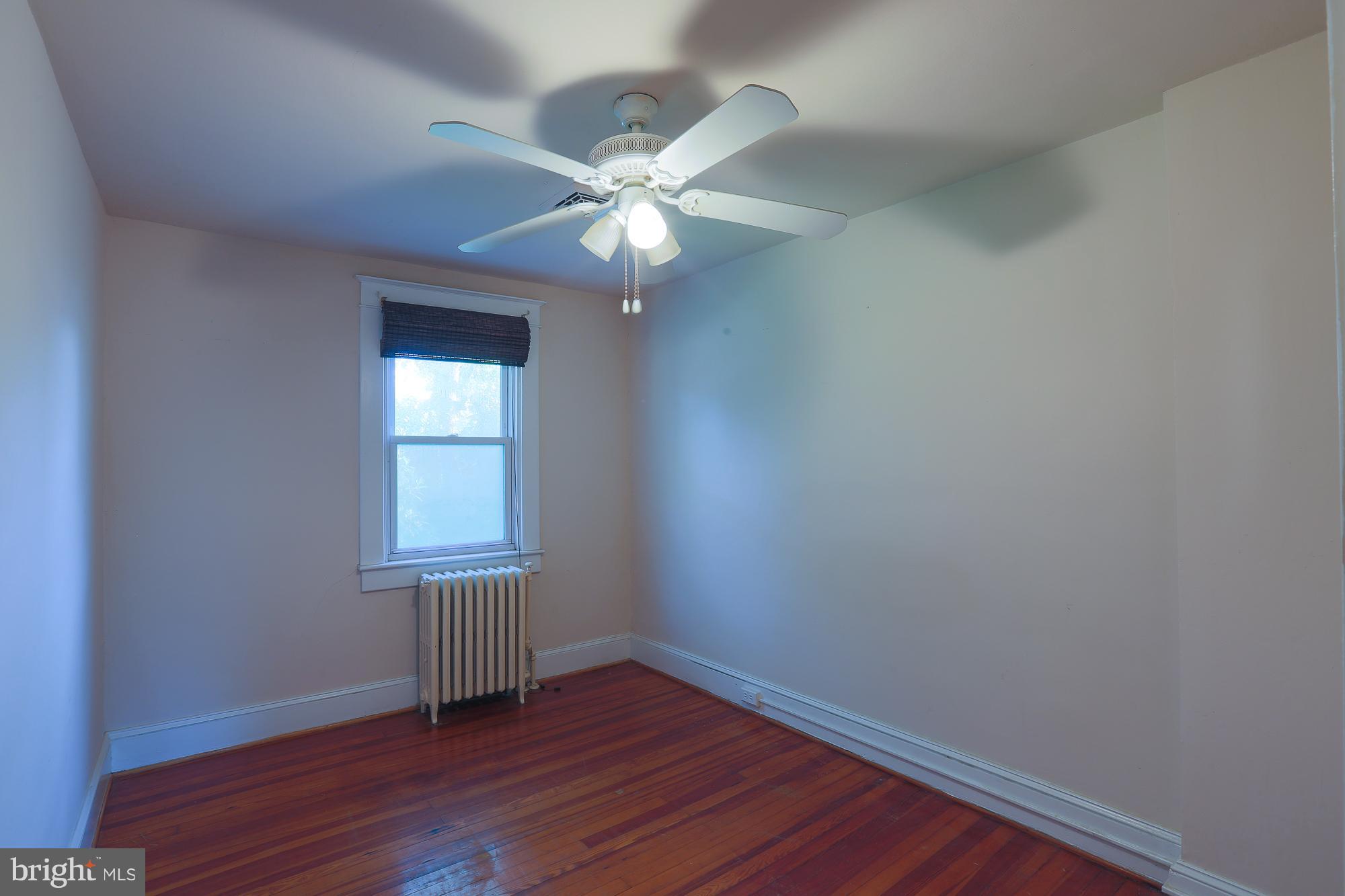 616 St Johns Road Baltimore, MD 21210 - Photo 13 of 15 an empty room with wooden floor fan and windows