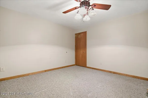 an empty room with a window and a fan