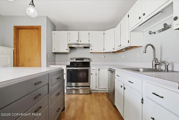 a kitchen with granite countertop white cabinets and stainless steel appliances
