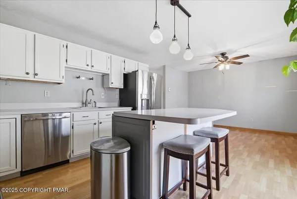a kitchen with stainless steel appliances granite countertop a sink a stove and refrigerator