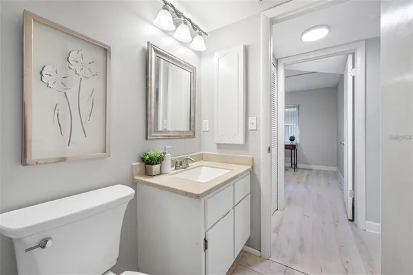 a bathroom with a granite countertop sink mirror and toilet