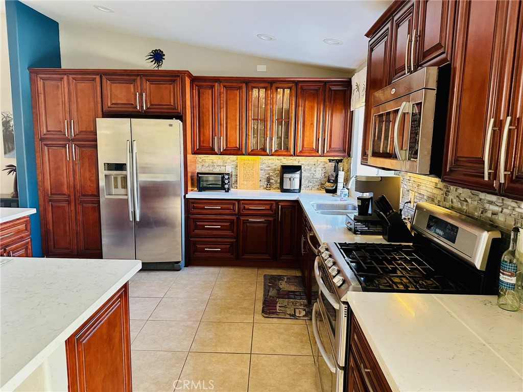67810 Ontina Road Cathedral City, CA 92234 - Photo 13 of 43 a kitchen with stainless steel appliances granite countertop a stove refrigerator sink and cabinets