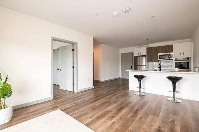 a living room with stainless steel appliances kitchen island furniture and wooden floor