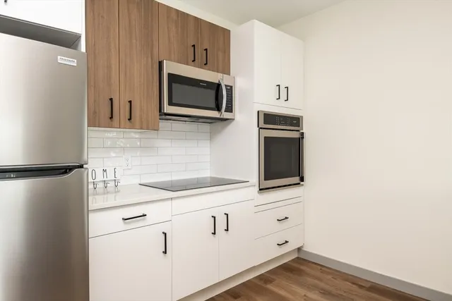 a kitchen with white cabinets and stainless steel appliances