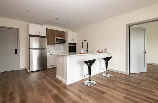 a kitchen with kitchen island a sink appliances and cabinets