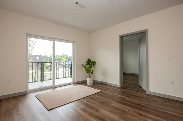 a view of a room with wooden floor and a window