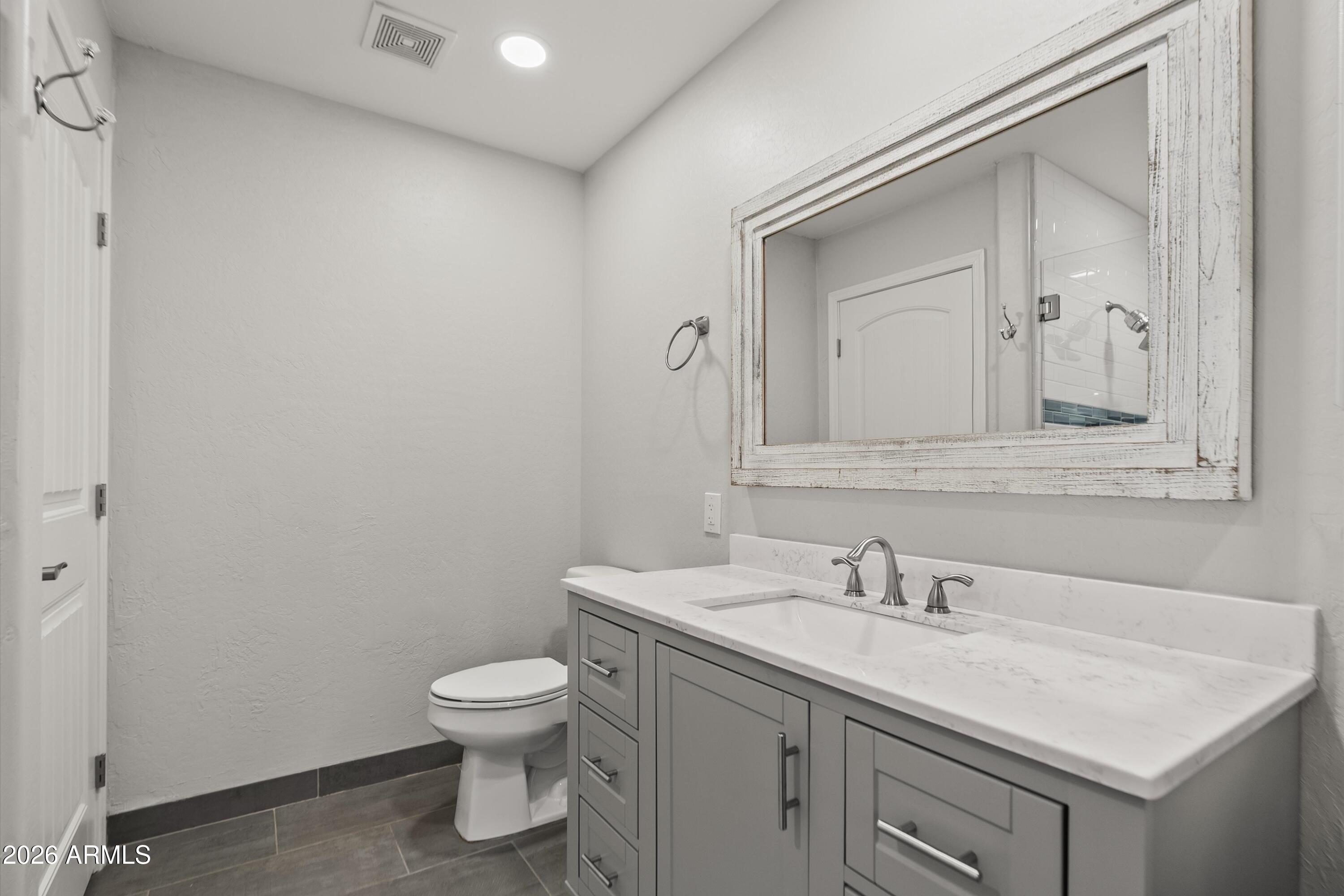 15649 North 29th Place Phoenix, AZ 85032 - Photo 21 of 35 a bathroom with a granite countertop sink a toilet and a mirror