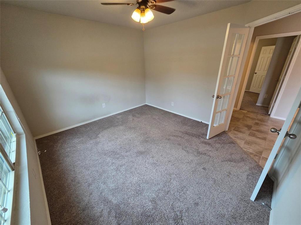 7504 Boat Wind Road Fort Worth, TX 76179 - Photo 4 of 17 an empty room with a ceiling fan and window