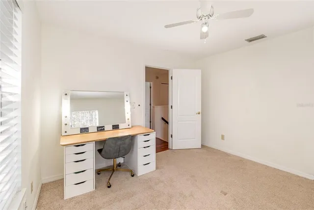 a view of a bedroom with a furniture and a ceiling fan