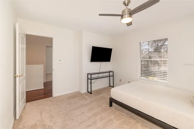 a bedroom with a bed tv and a window