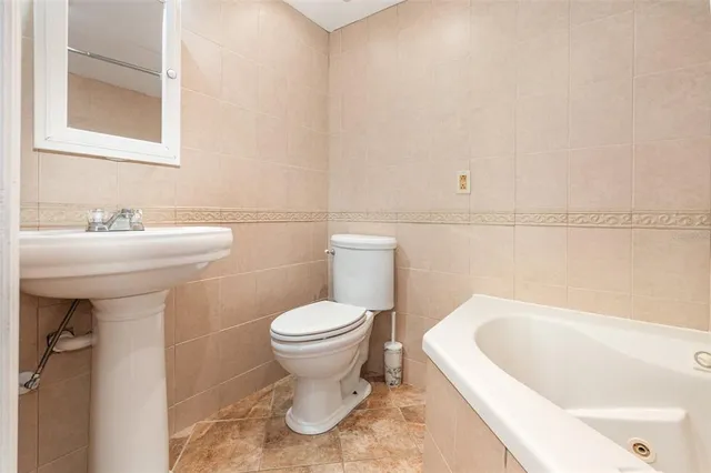 a bathroom with a sink a toilet and mirror