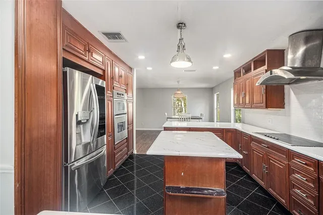 a kitchen with stainless steel appliances granite countertop a refrigerator and a sink