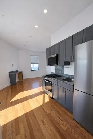 a kitchen with granite countertop a refrigerator stove top oven and sink