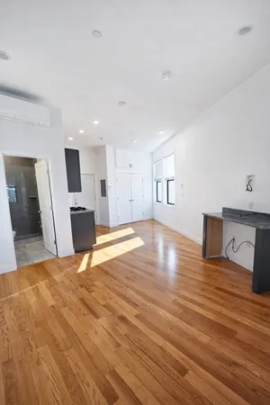 a view of a kitchen with kitchen island microwave and wooden floor