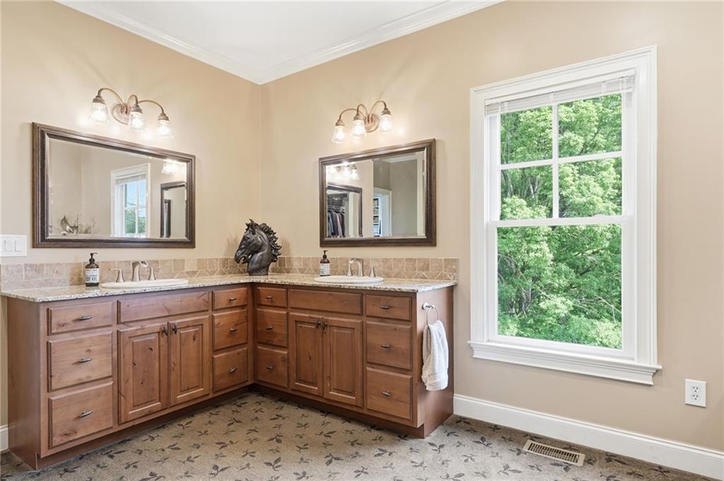 3535 Dr Bramblett Road Cumming, GA 30028 - Photo 37 of 91 a spacious bathroom with a double vanity sink a mirror and a window