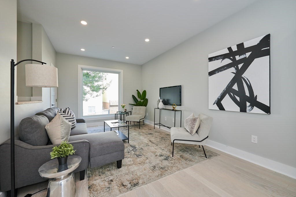 a living room with furniture a rug and a flat screen tv
