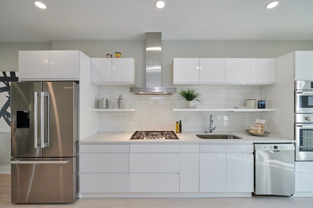 96 Cottage Street, Unit PARLOR Boston, MA 02128 - Photo 4 of 15 a kitchen with a refrigerator and white cabinets