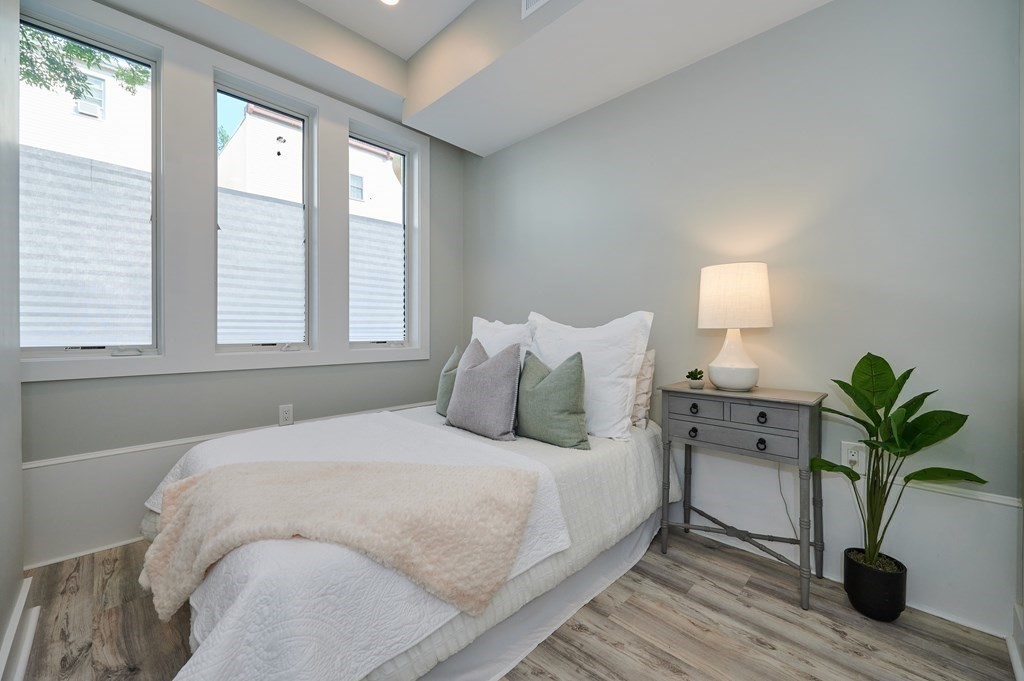 96 Cottage Street, Unit PARLOR Boston, MA 02128 - Photo 9 of 15 a bedroom with a bed running cycle and a window