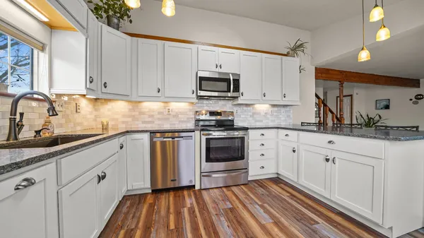 a kitchen with white cabinets stainless steel appliances and sink