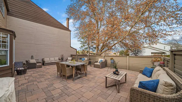 a view of a patio with couches and table and chairs and potted plants