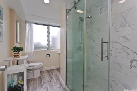 a bathroom with a granite countertop sink a toilet and shower