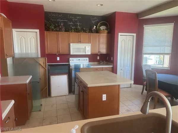 a view of kitchen with cabinets and window