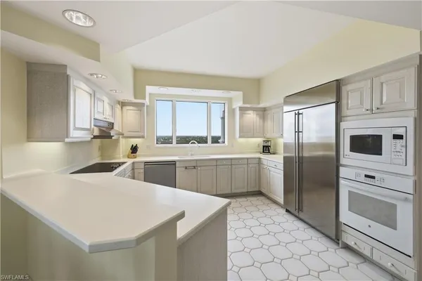 a kitchen with stainless steel appliances a refrigerator sink and cabinets