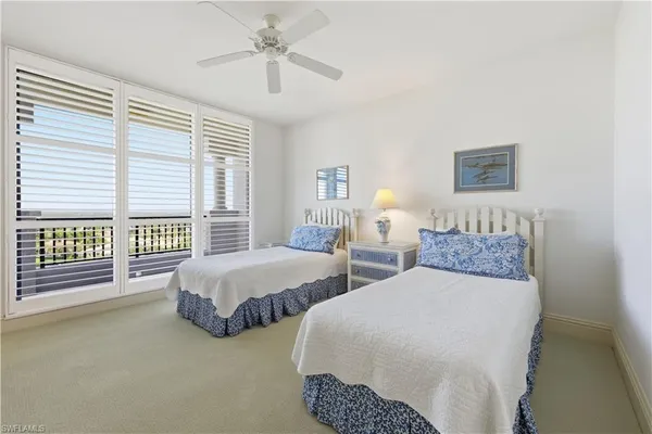 a spacious bedroom with two beds and a chandelier
