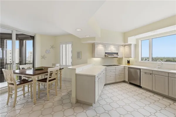 a large white kitchen with cabinets and chairs