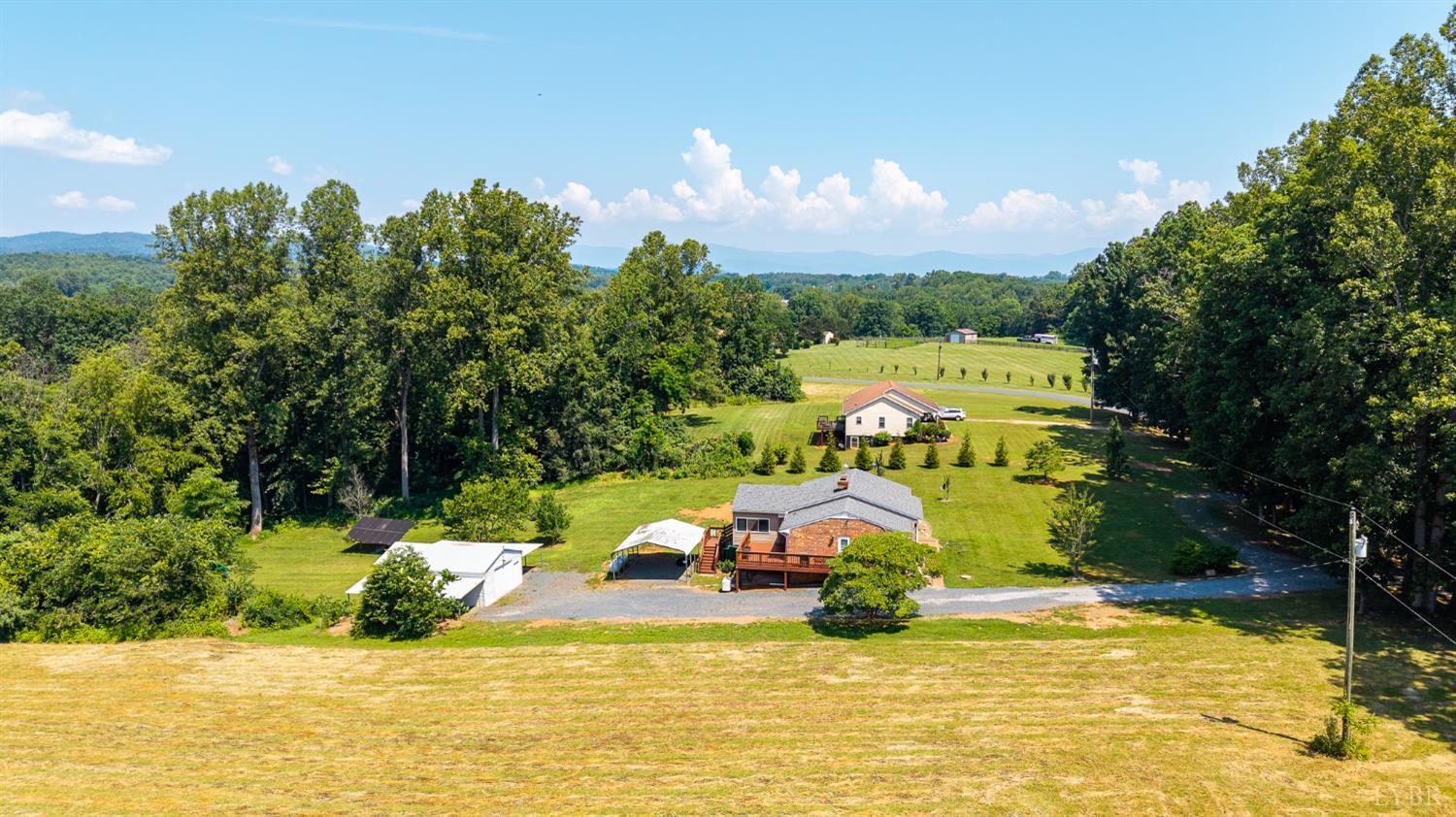 1553 Old Stage Road Amherst, VA 24521 - Photo 2 of 61 a view of a lake with lawn chairs and large trees