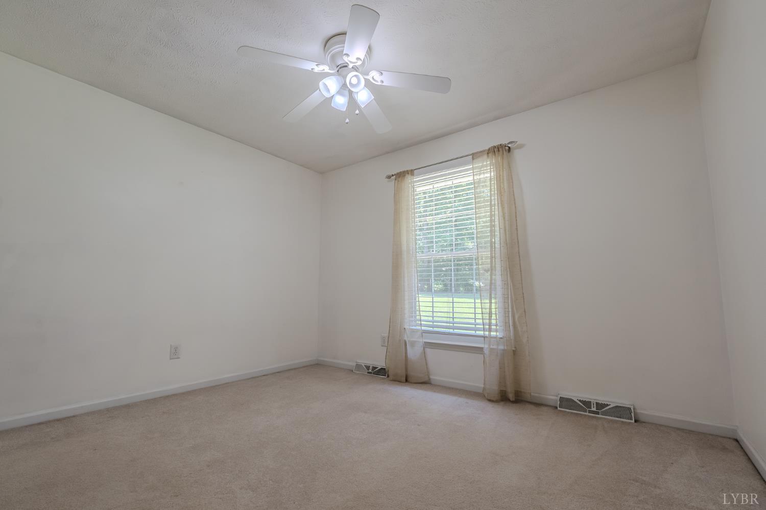 1553 Old Stage Road Amherst, VA 24521 - Photo 41 of 61 an empty room with a chandelier fan and windows