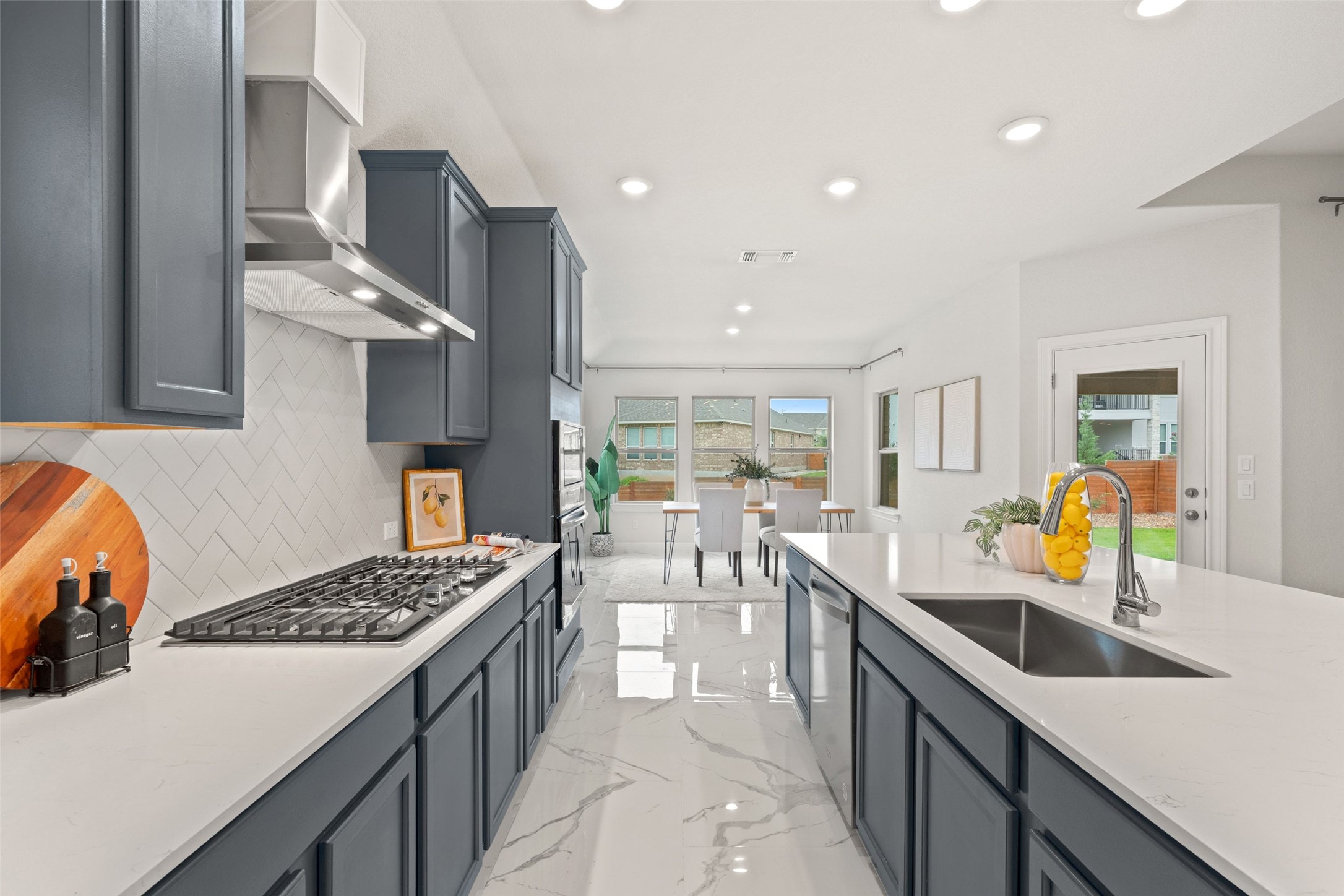 1513 Hinterwald Street Leander, TX 78641 - Photo 6 of 40 a kitchen with a sink a counter and chairs