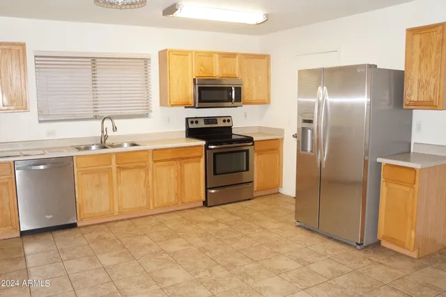 a kitchen with stainless steel appliances granite countertop a stove a sink and a refrigerator