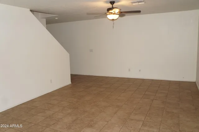an empty room with a chandelier fan