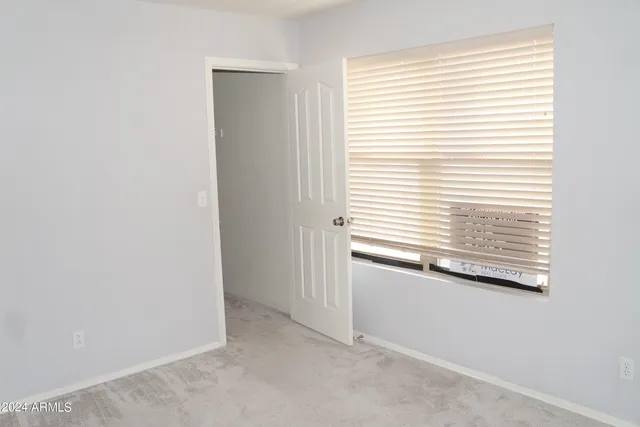an empty room with a chandelier fan
