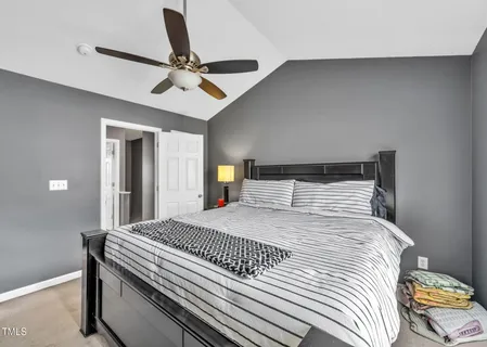 a bedroom with a large bed and a chandelier